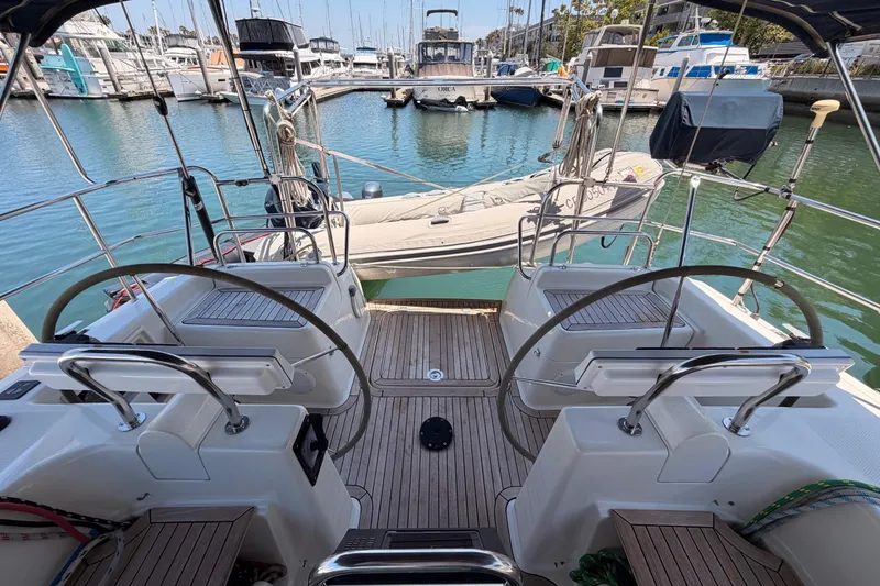 Slide: The Image of 2006 Hanse 461 yacht cockpit with dual steering wheels, docked in a marina. - 29