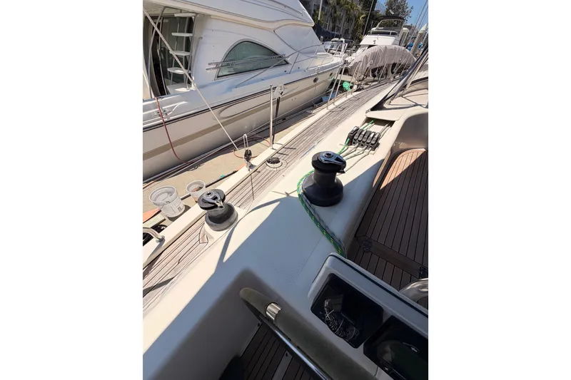 Slide: The Image of 2006 Hanse 461 yacht deck with winches and ropes, docked beside another boat. - 37