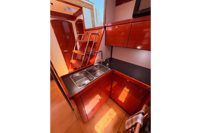 Slide: The Image of Interior of 2006 Hanse 461 yacht kitchen with wooden cabinets and stainless steel sink. - 48