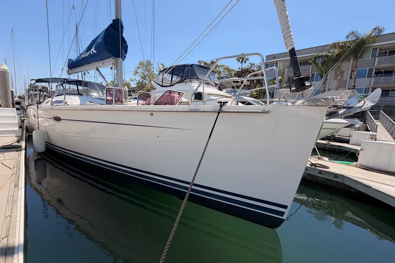Slide: The Image of 2006 Hanse 461 sailboat docked at marina, featuring sleek white hull and blue sail cover. - 5