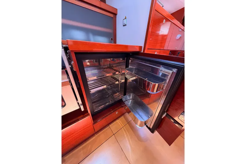 Slide: The Image of Open refrigerator in 2006 Hanse 461 yacht interior, showcasing sleek wooden cabinetry. - 53