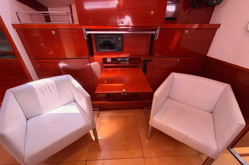 Slide: The Image of Luxurious 2006 Hanse 461 yacht interior with white chairs and sleek wooden cabinetry. - 60