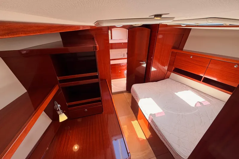 Slide: The Image of Luxurious wooden interior of a 2006 Hanse 461 yacht cabin with bed and storage. - 65