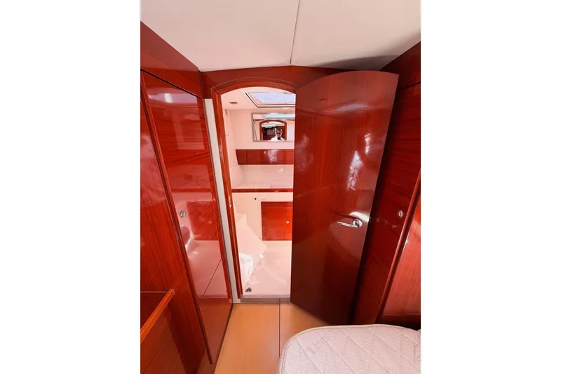 Slide: The Image of Interior of 2006 Hanse 461 yacht, featuring polished wood finishes and a partially open door. - 67