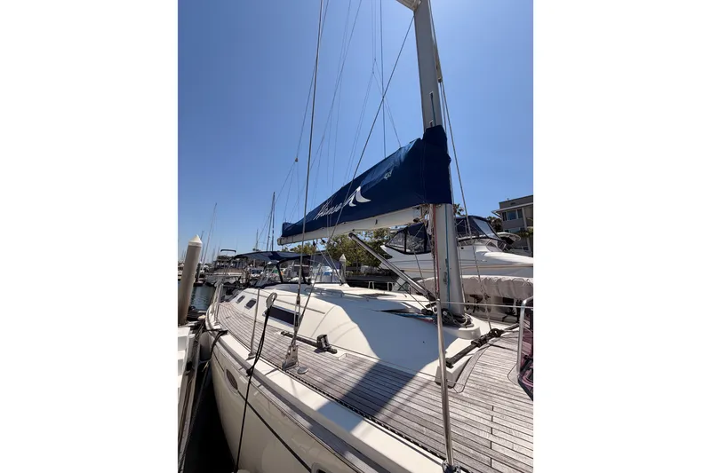 Slide: The Image of 2006 Hanse 461 sailboat docked, featuring sleek design and blue sail cover. - 7