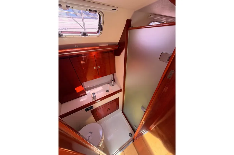 Slide: The Image of Interior of 2006 Hanse 461 yacht bathroom with wooden cabinetry and frosted glass door. - 78