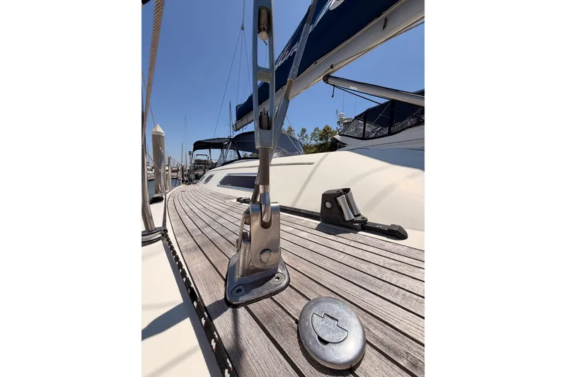 Slide: The Image of 2006 Hanse 461 yacht deck with sleek wooden finish and metal fittings under clear blue sky. - 8