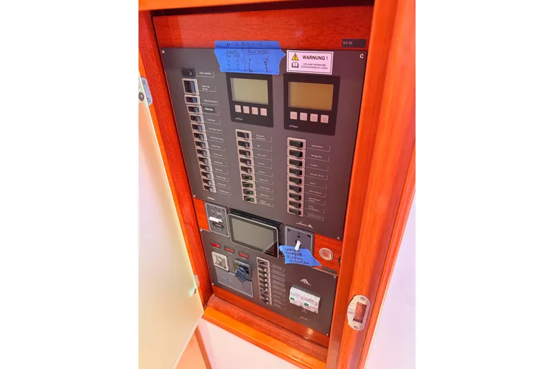 Slide: The Image of Electrical control panel inside a 2006 Hanse 461 yacht, featuring switches and displays. - 81
