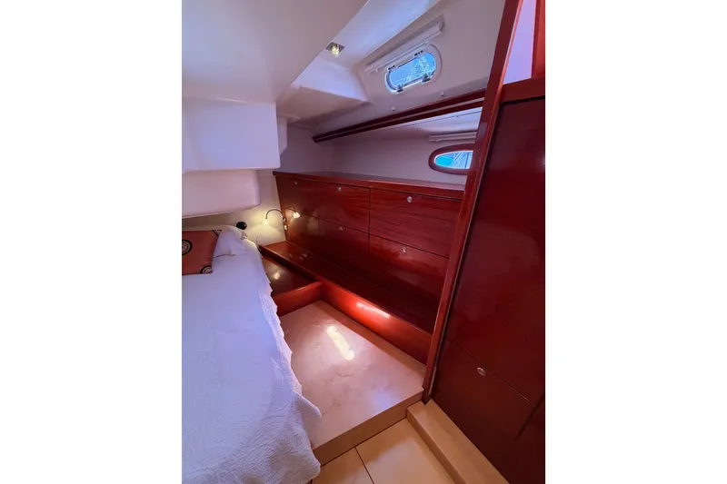 Slide: The Image of Interior cabin of 2006 Hanse 461 yacht with wooden cabinetry and cozy bed. - 85