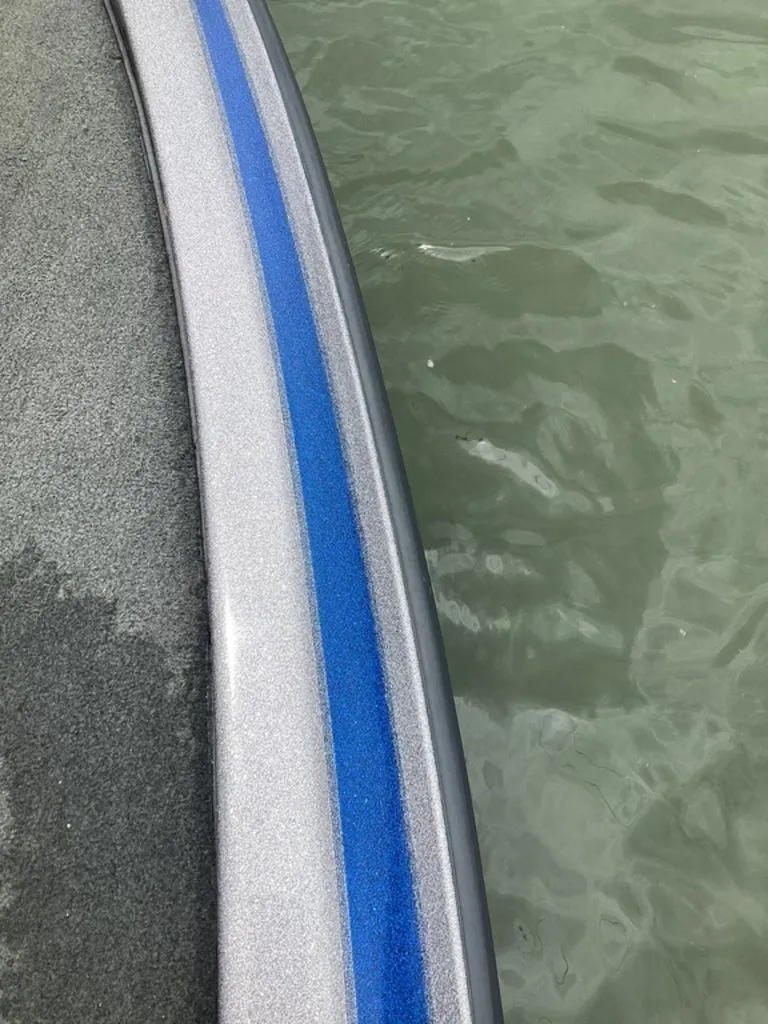 Slide: The Image of Close-up of a 2017 Skeeter ZX250 boat by the water. - 27