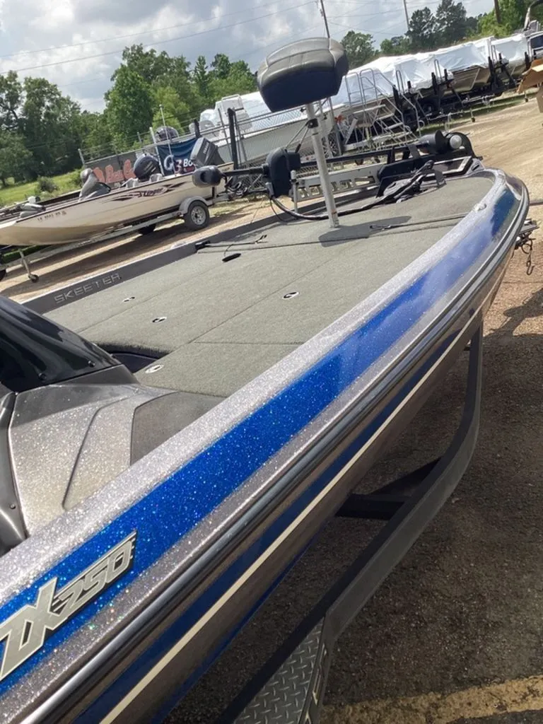 Slide: The Image of 2017 Skeeter ZX250 boat with blue stripe on a trailer. - 43