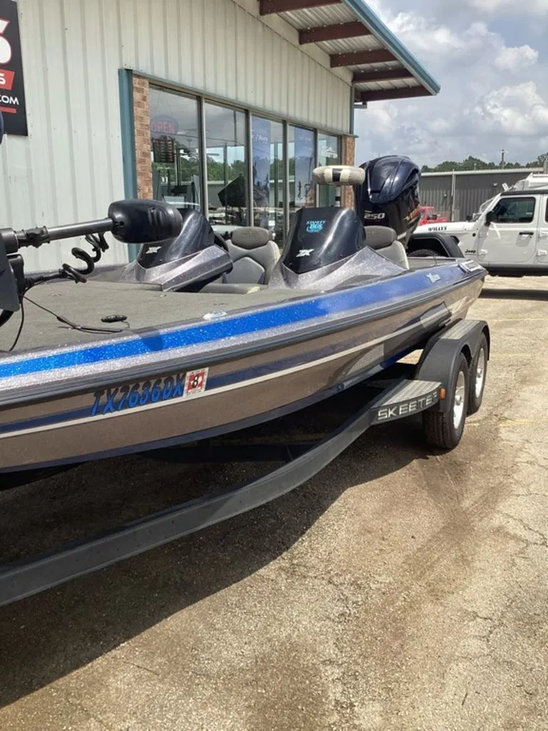 Slide: The Image of 2017 Skeeter ZX250 boat on trailer outside a building. - 48