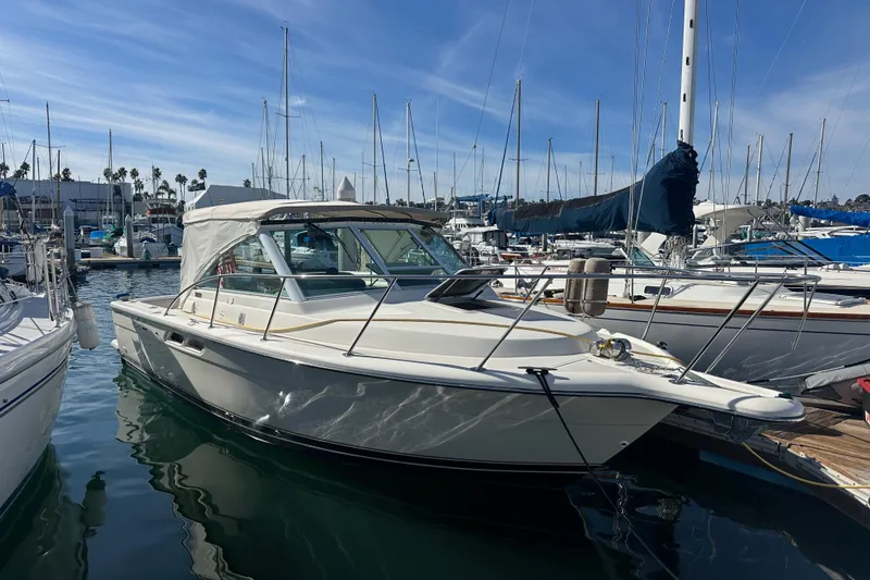 The Image of 1998 Tiara Yachts 2900 Coronet docked in a marina under a clear blue sky. - 1