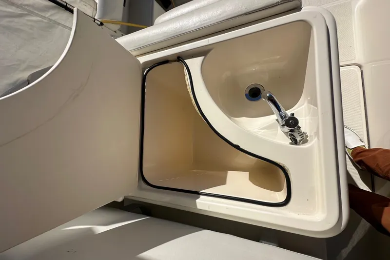 Slide: The Image of Open sink compartment on 1998 Tiara Yachts 2900 Coronet, featuring a chrome faucet. - 11