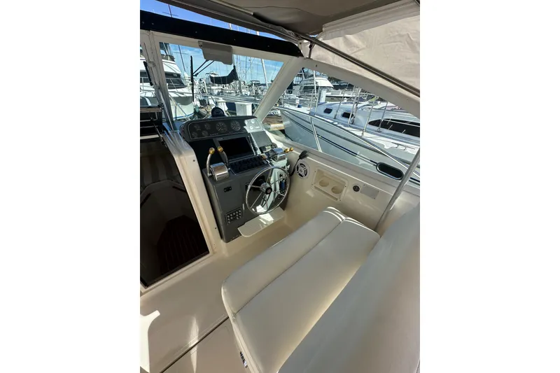 Slide: The Image of 1998 Tiara Yachts 2900 Coronet cockpit with steering wheel and control panel, docked at marina. - 13