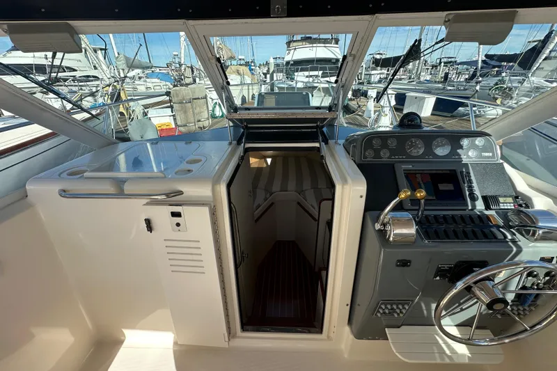 Slide: The Image of 1998 Tiara Yachts 2900 Coronet cockpit with helm and cabin entrance at marina. - 18