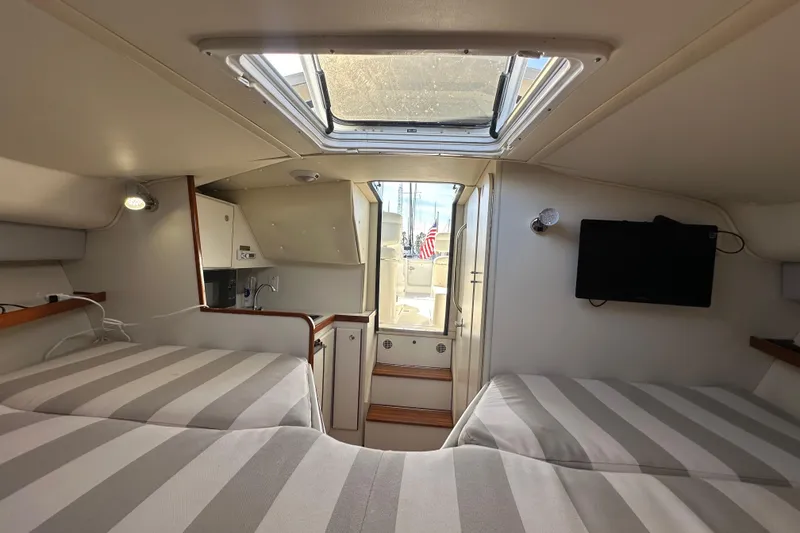 Slide: The Image of Interior of 1998 Tiara Yachts 2900 Coronet with striped bedding and skylight. - 22