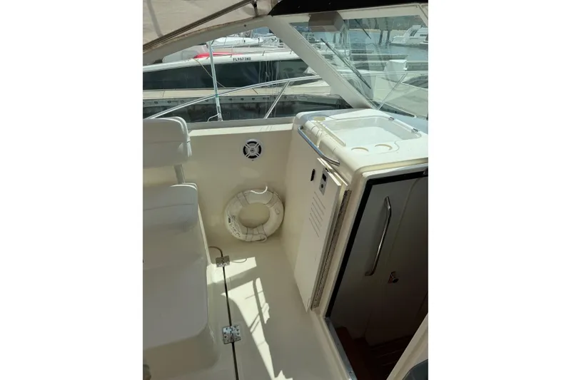 Slide: The Image of 1998 Tiara Yachts 2900 Coronet interior with seating and storage, docked at marina. - 43