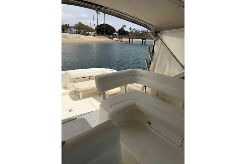 Slide: The Image of 1998 Tiara Yachts 2900 Coronet interior with white seating, overlooking calm waters and a sandy shore. - 47