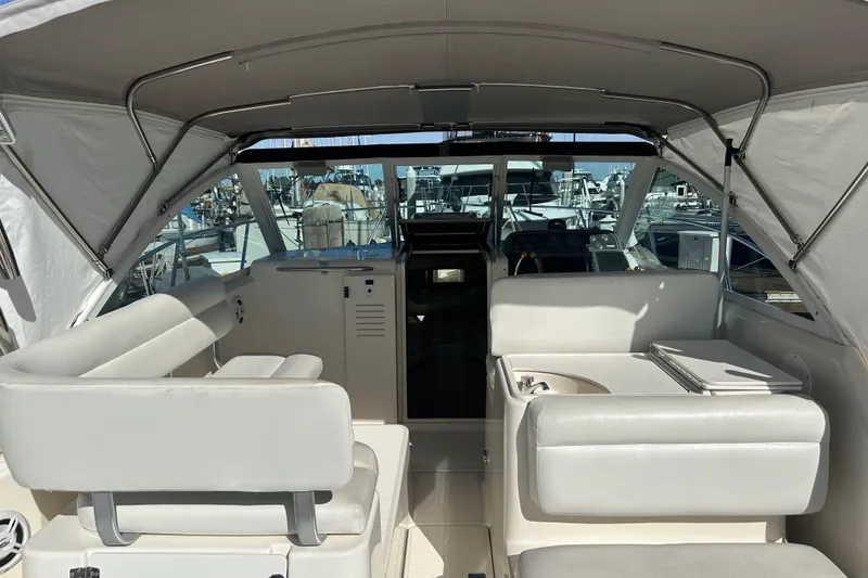Slide: The Image of 1998 Tiara Yachts 2900 Coronet interior with white seating and helm, docked at marina. - 6