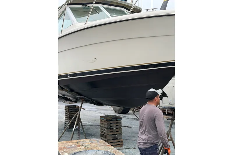 Slide: The Image of 1998 Tiara Yachts 2900 Coronet on stands, with a person inspecting the hull. - 50