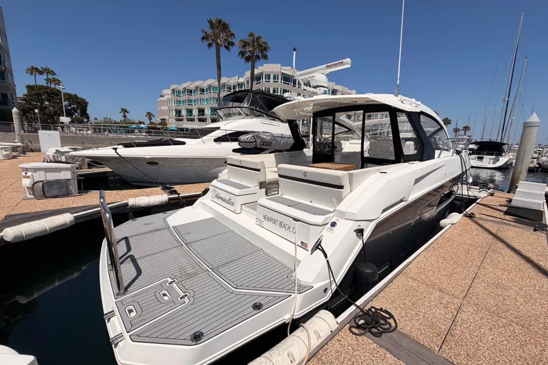 Slide: The Image of 2020 Cruisers Yachts 390 Express Coupe docked at marina under clear blue sky. - 11