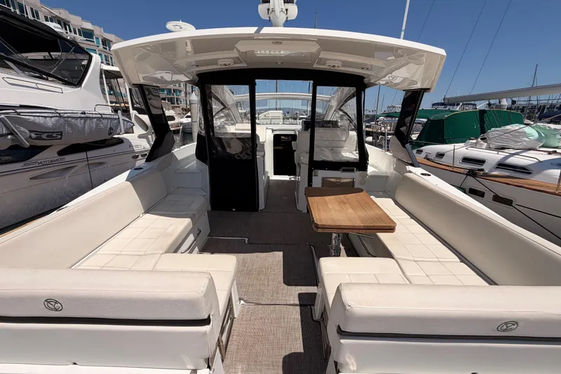 Slide: The Image of 2020 Cruisers Yachts 390 Express Coupe interior with seating and table at marina. - 14