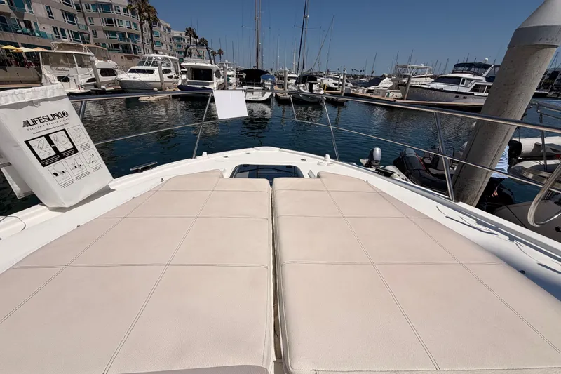 Slide: The Image of 2020 Cruisers Yachts 390 Express Coupe at marina, featuring spacious sunbathing deck. - 23