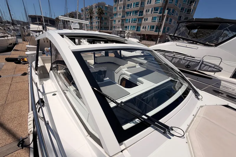 Slide: The Image of 2020 Cruisers Yachts 390 Express Coupe docked at marina, modern design, sunny day. - 26