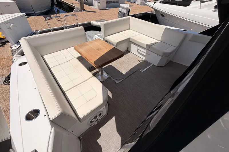 Slide: The Image of 2020 Cruisers Yachts 390 Express Coupe interior with white seating and wooden table. - 28
