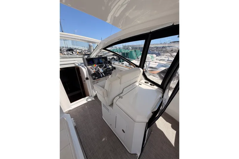 Slide: The Image of 2020 Cruisers Yachts 390 Express Coupe helm with modern controls and panoramic windows. - 34
