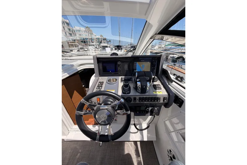 Slide: The Image of 2020 Cruisers Yachts 390 Express Coupe helm with navigation screens and controls. - 36