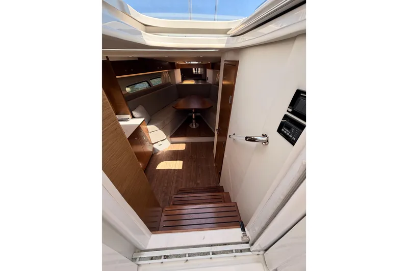Slide: The Image of Interior view of 2020 Cruisers Yachts 390 Express Coupe, featuring elegant wood finishes and seating area. - 43