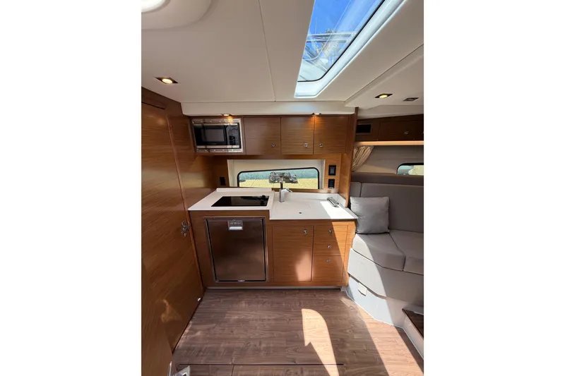 Slide: The Image of Interior of 2020 Cruisers Yachts 390 Express Coupe, featuring modern kitchen and seating area. - 55