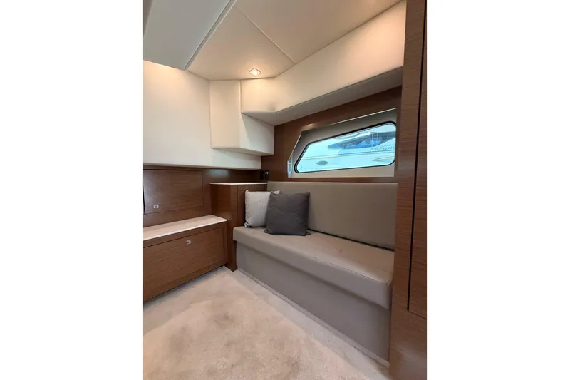 Slide: The Image of Interior of 2020 Cruisers Yachts 390 Express Coupe, featuring a cozy seating area with window. - 58