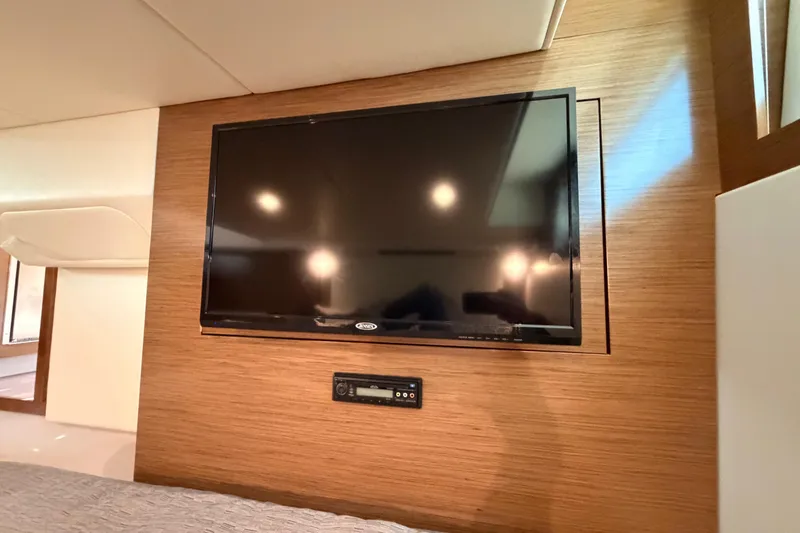 Slide: The Image of Flat-screen TV in 2020 Cruisers Yachts 390 Express Coupe interior, mounted on wood paneling. - 62
