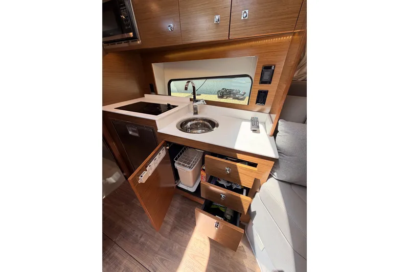 Slide: The Image of Modern kitchen interior of 2020 Cruisers Yachts 390 Express Coupe with wood cabinetry and appliances. - 73