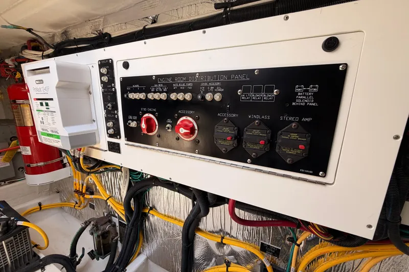 Slide: The Image of Engine room distribution panel of 2020 Cruisers Yachts 390 Express Coupe with wiring and safety equipment. - 82