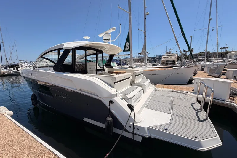 Slide: The Image of 2020 Cruisers Yachts 390 Express Coupe docked at marina, showcasing sleek design and spacious deck. - 9