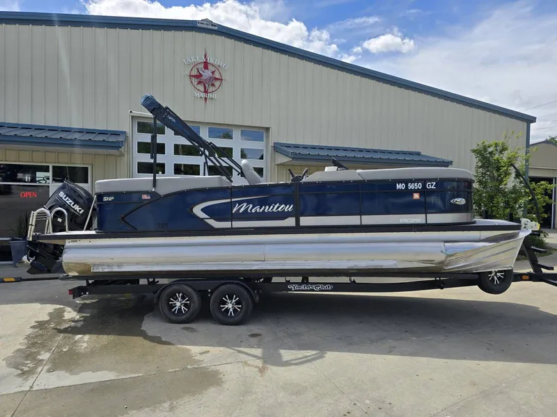 Slide: The Image of 2022 Manitou 23 Encore RF SHP pontoon boat in front of a building. - 5