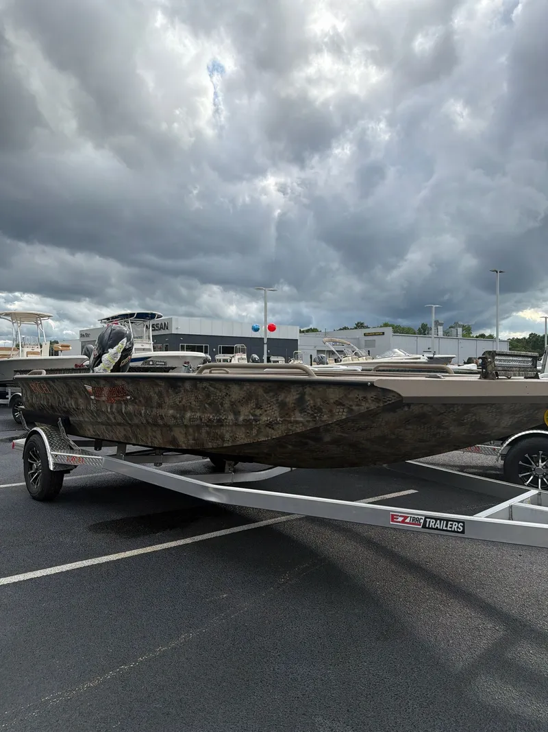 Slide: The Image of Excel 183 Tomahawk boat on trailer under cloudy sky. - 3