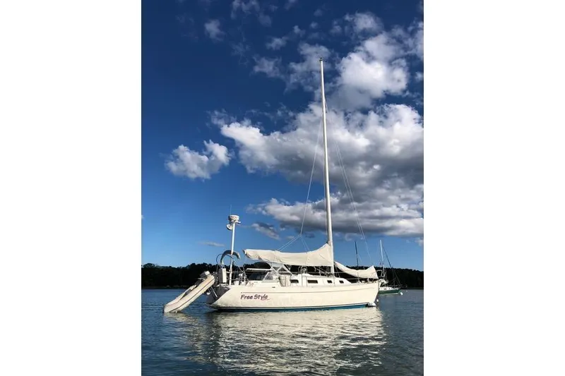 The Image of Sailboat "Free Style" on calm water, Freedom 35 model, 1996, under a blue sky. - 0
