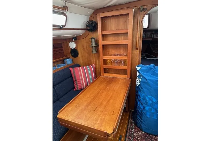 Slide: The Image of Interior of a 1996 Freedom 35 sailboat with wooden table and seating area. - 10