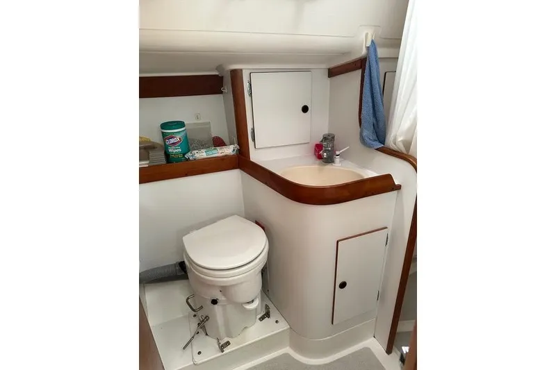 Slide: The Image of Compact bathroom in a 1996 Freedom 35 yacht, featuring a toilet and sink with storage. - 11