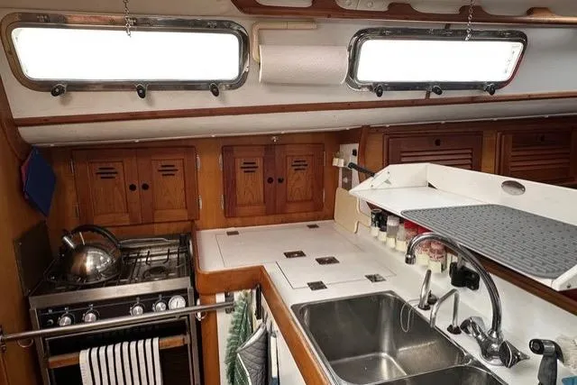 Slide: The Image of 1996 Freedom 35 yacht kitchen with stove, sink, and wooden cabinets. - 13
