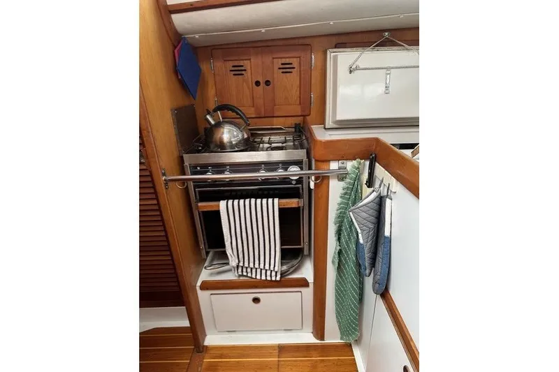 Slide: The Image of Compact kitchen area in a 1996 Freedom 35 sailboat with stove and kettle. - 14