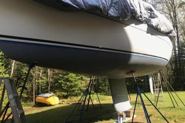 Slide: The Image of Sailboat Freedom 35 (1996) on stands, covered, in a grassy area with trees. - 15