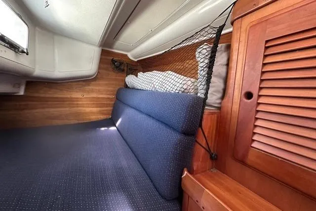 Slide: The Image of Cozy cabin interior of a 1996 Freedom 35 sailboat with blue cushions and wooden accents. - 3