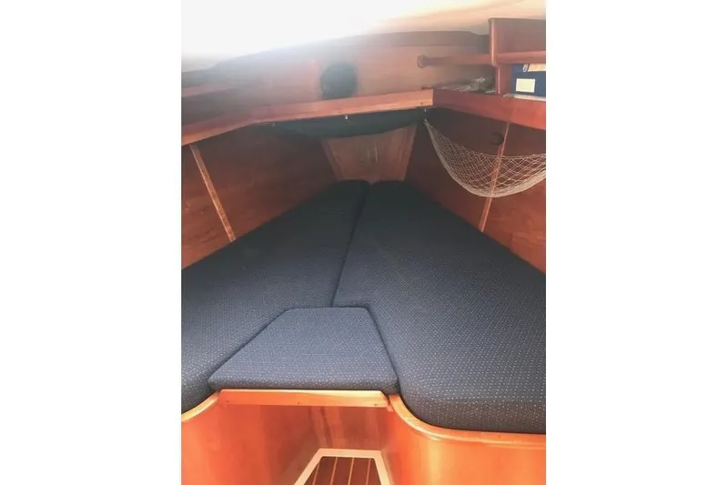 Slide: The Image of Cozy cabin interior of 1996 Freedom 35 sailboat with blue cushions and wooden finish. - 4