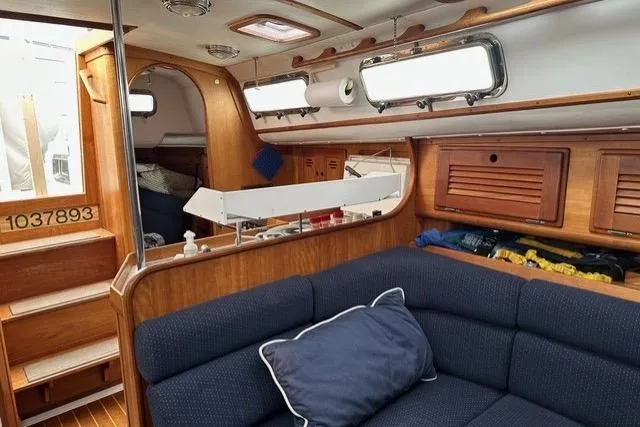 Slide: The Image of Interior of a 1996 Freedom 35 sailboat with wooden finishes and blue seating. - 6